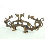 A Chinese, bronze pen rest in the form of entangled, mythical beasts