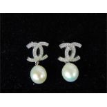 A pair of CZ and freshwater pearl earrings.