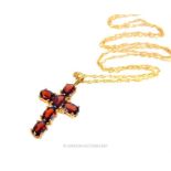 A boxed, 9 ct yellow gold, garnet-set cross pendant on 9 ct yellow gold chain