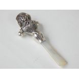 A sterling silver babies rattle with mother of pearl handle.