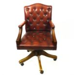 A burgundy buttoned leather office open armchair