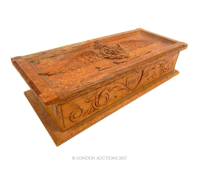 A homemade WW1 RFC carved wooden scribe box; with the RFC insignia carved upon its top; 23cm wide.