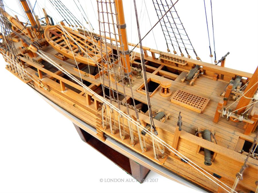 A wooden plank built model of the HMS Bounty with stand; approximately 93cm long overall. - Image 3 of 4