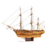 A wooden plank built model of the HMS Bounty with stand; approximately 93cm long overall.