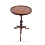 A mahogany and brass inlaid occasional table on three, splayed legs