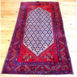 A Persian Malayer rug with a deep red ground