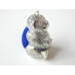 A silver bear shaped pin cushion.