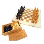 A marble, white and brown onyx chessboard with carved East African chess pieces