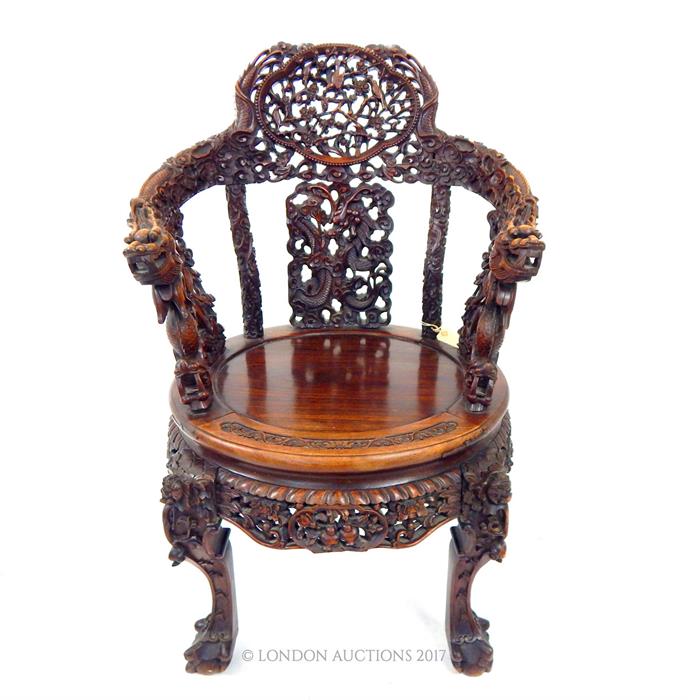 A late 19th century Chinese carved hardwood elbow chair with both armrests carved with dragons, a