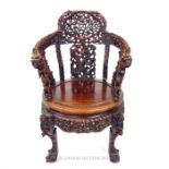 A late 19th century Chinese carved hardwood elbow chair with both armrests carved with dragons, a