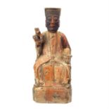 An eastern carved 19th century, wooden figure of a holy man seated with one hand raised; with traces