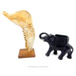 A Cuban sculpture formed of a carved cattle jawbone, with a model elephant