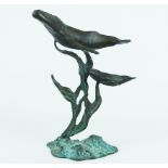 A bronzed, sculpture depicting two blue wales and sea-weed tendrils