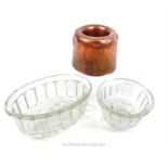 A Victorian copper jelly mould, together with two glass jelly moulds