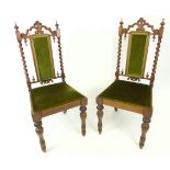 A pair of carved mahogany side chairs in the Gothic style.