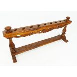 A Southeast Asian hardwood kris stand to hold nine kris, the upper edges carved with a running