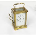 A brass carriage clock with Roman numeral dial, with key.