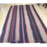 A large kelim rug, with repeating dark and light brown stripes