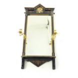 A contemporary black and gold mirror with gilt metal candle holders.