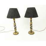 A pair of black and gold coloured papier mache lamps with shades.