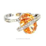 An 18 ct white gold and diamond and orange stone dress ring