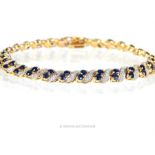 A 19 ct yellow and white gold, sapphire and diamond tennis bracelet