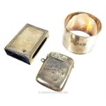 A late Victorian sterling silver vesta case, a matchbox holder and napkin ring