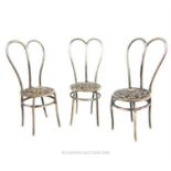 A set of three miniature late 19th century Continental silver dining chairs