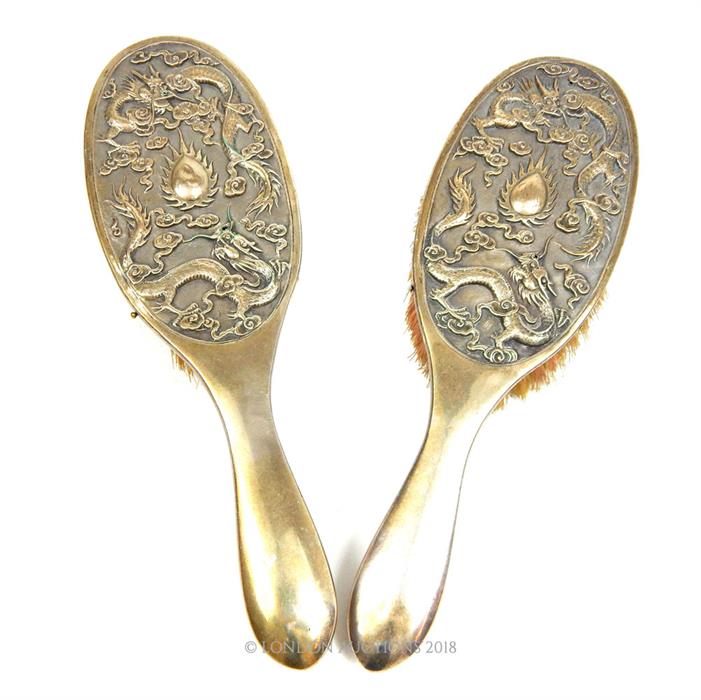 A pair of Chinese silver brushes, decorated in relief