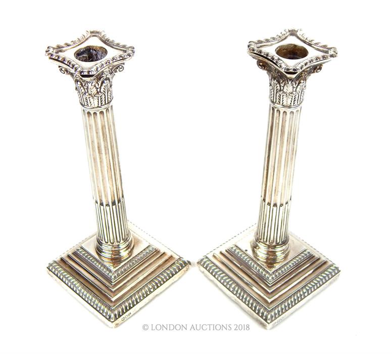 A pair of Edwardian sterling silver Corinthian column candlesticks
