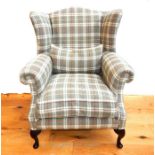 A modern wing back armchair, upholstered in checked fabric