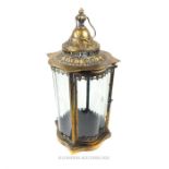 A gilt metal storm lantern with four curved glass panels