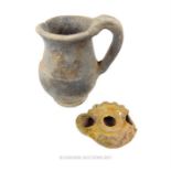 A Roman oil lamp (with traces of a green glaze) with a Roman earthenware jug