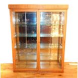 A 1940's light oak glazed two door display cabinet, with four glass shelves 158 x 125 x 29 cm