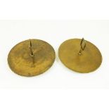 A pair of circular bronze trays with handles