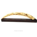 A 1920's, West African, carved ivory tusk with wooden stand (a/f)