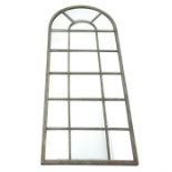 A large distressed rounded arch mirror