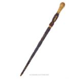 An eastern twine covered swagger stick with yellow metal knop; 60cm long.
