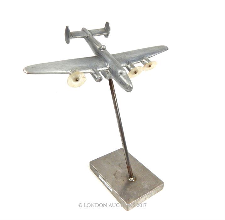 A white metal model of a WW2 Halifax bomber, on stand.