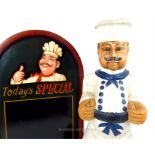 A carved and painted figure of a chef and a special's board