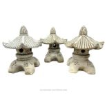 Three small composite stone ornaments with pagoda tops.
