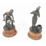A pair of southeast Asian bronze figures on wooden stands