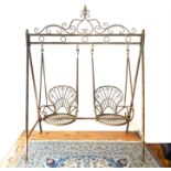 A distressed metal framed double seated, swinging garden chair.