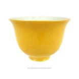 A Chinese, porcelain tea cup with a yellow exterior glaze