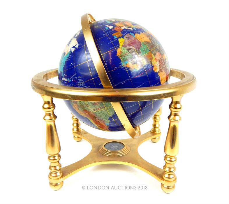 A contemporary semi precious stone globe on a brass stand