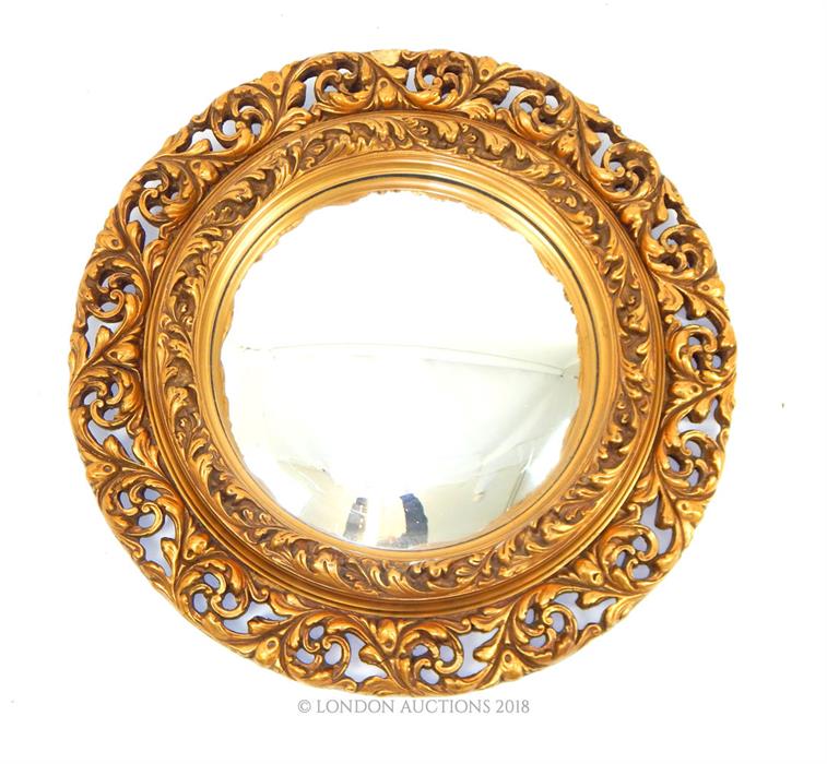 A vintage, carved, gilt-wood, circular wall mirror with convex glass panel