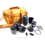 A Minolta camera with extra lenses and parts in a canvas, 'Billingham' carry case