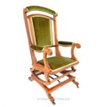 A Victorian, carved oak-framed rocking chair with green velvet upholstery