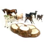 Collection of Beswick horses, cow, and Beswick tree stump display stand, together with a Basil