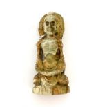 An Oriental carved bone figure of a seated starving Buddha